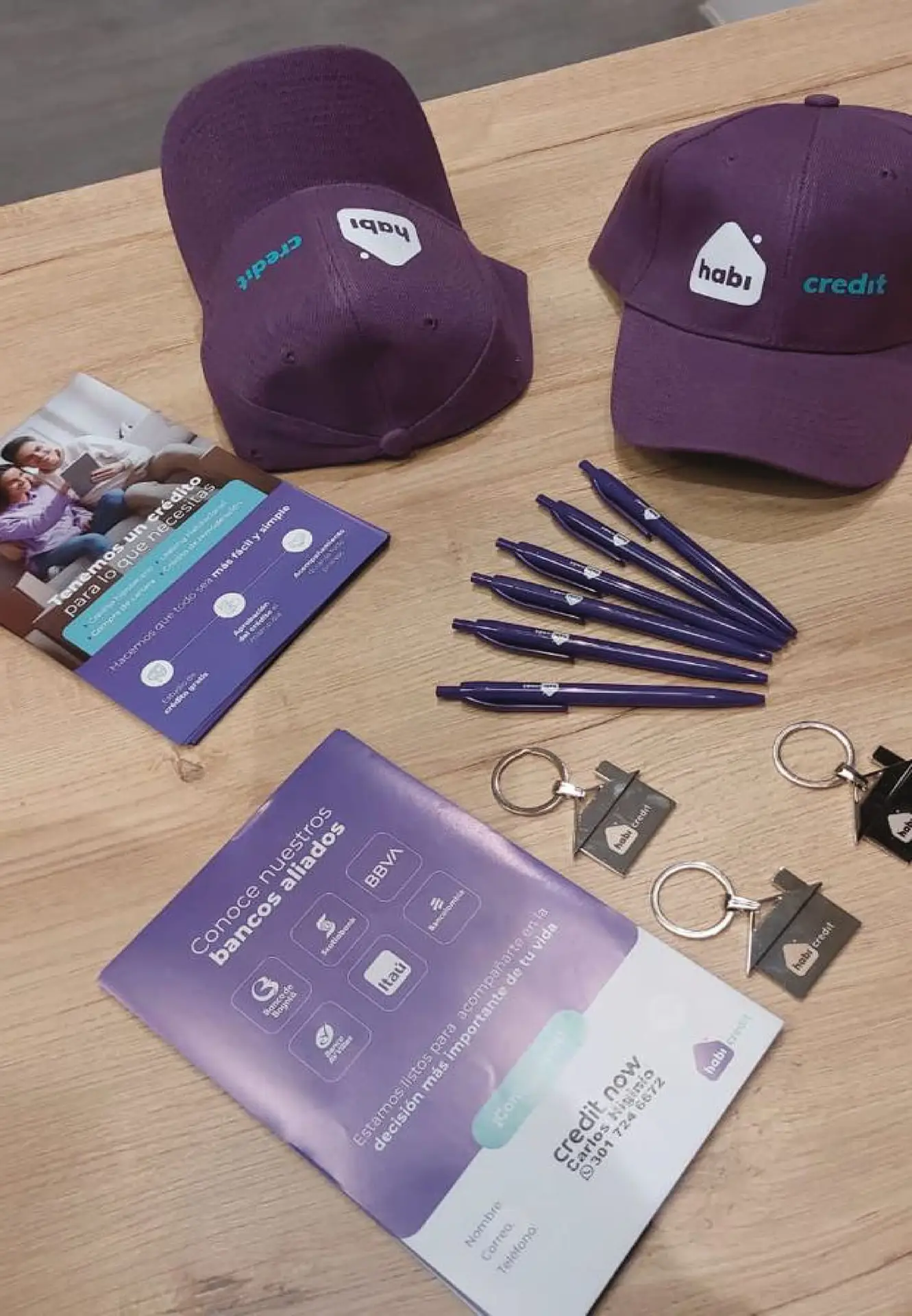 Kit de souvenirs corporativos para Habi: incluye gorras bordadas, esferos personalizados, llaveros metálicos y material impreso, producidos integralmente por Bresspop Publicidad.