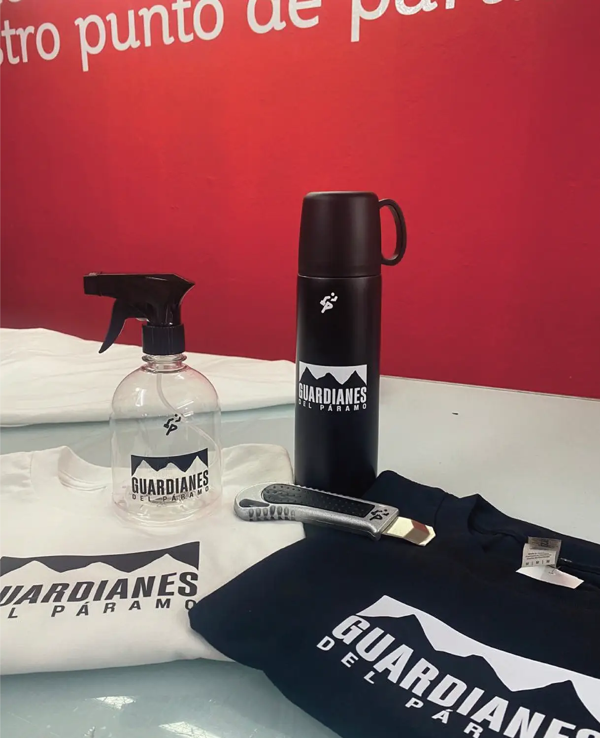 Kit promocional personalizado de souvenirs: incluye camisetas negra y blanca marcadas, termo metálico y botella atomizadora con logo para eventos de Bresspop, perfecto para marketing promocional de alto impacto.